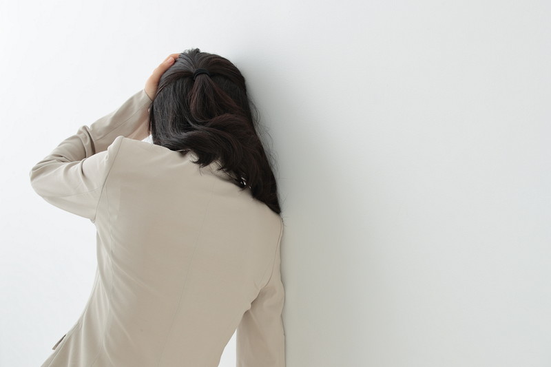壁に寄りかかっている女性