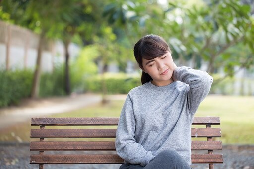 首がつらそうな女性